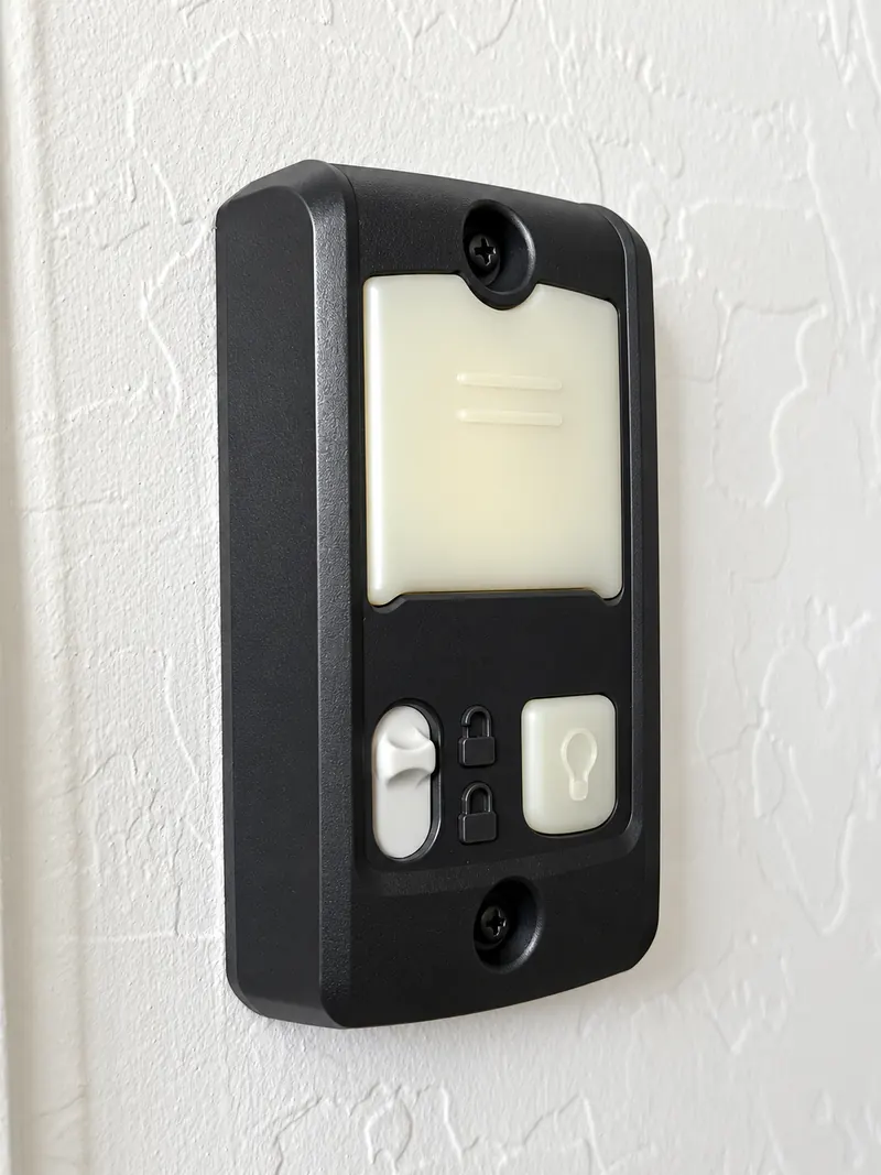 A garage door wall control with a large push button, a lock slider and a light button